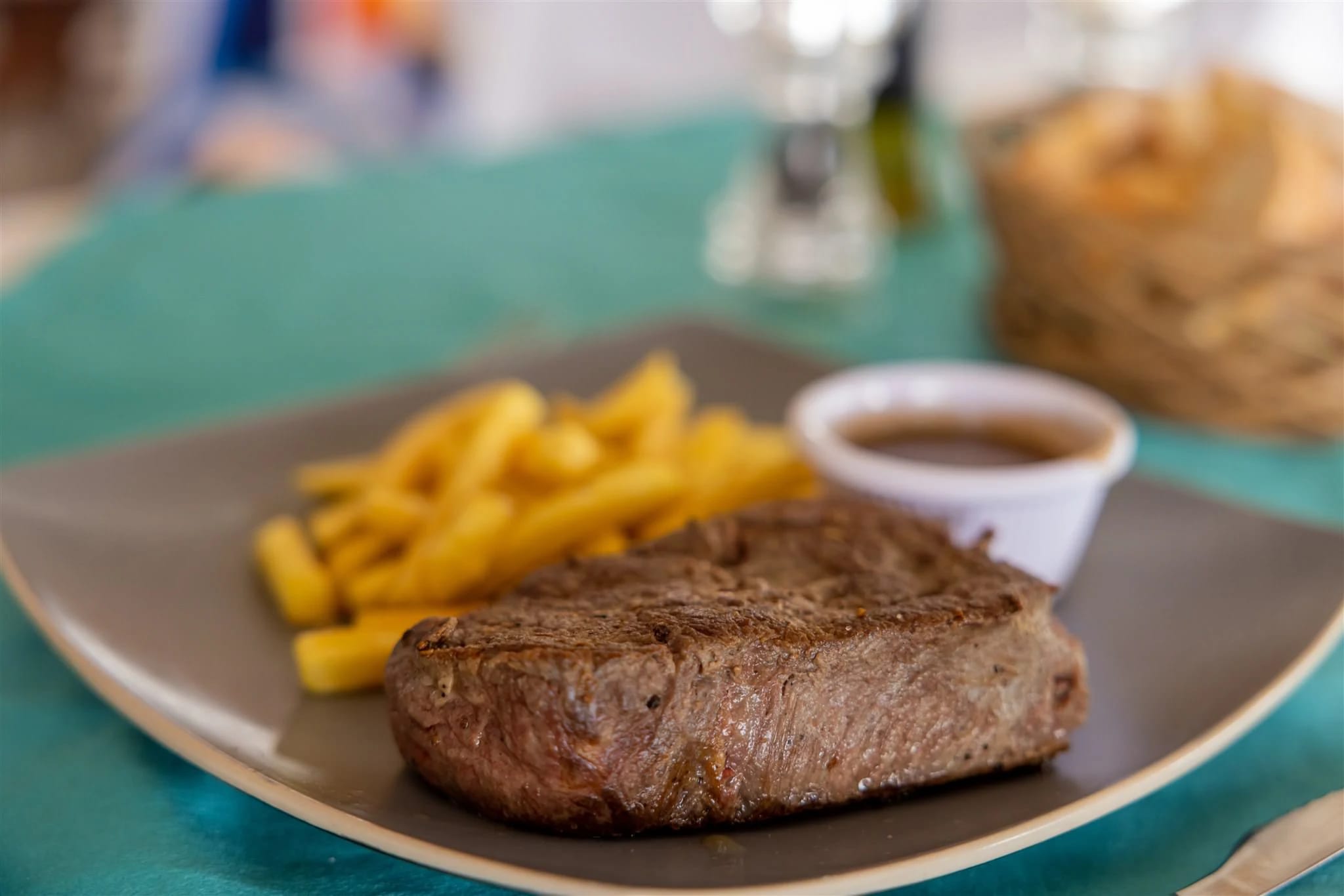 Grilled steak plate with fries and sauce