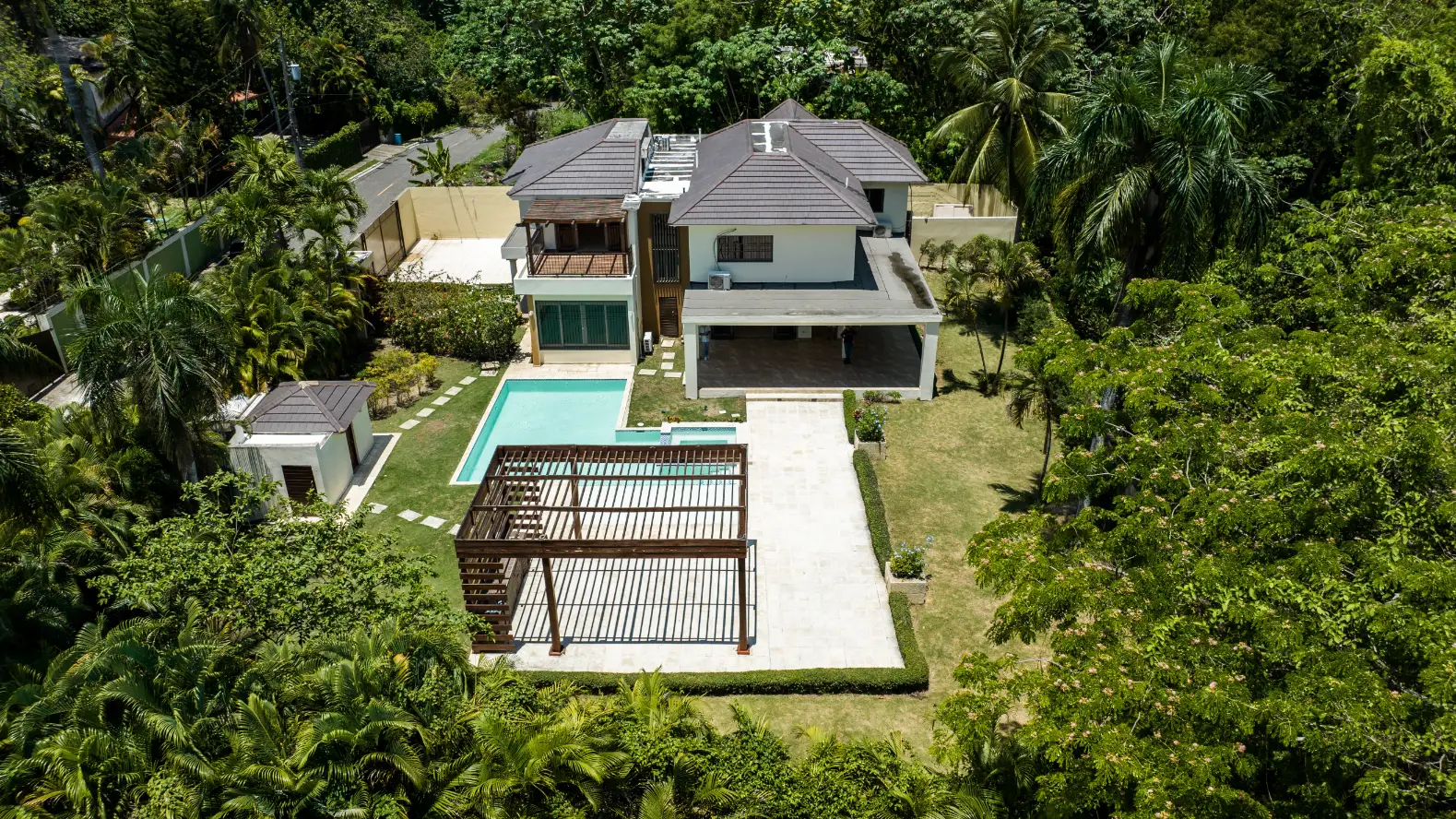 Luxury Mansion Viewed from Above Aerial drone photograph of luxury Santo Domingo mansion featuring turquoise pool, white terrace and lush tropical gardens from overhead perspective