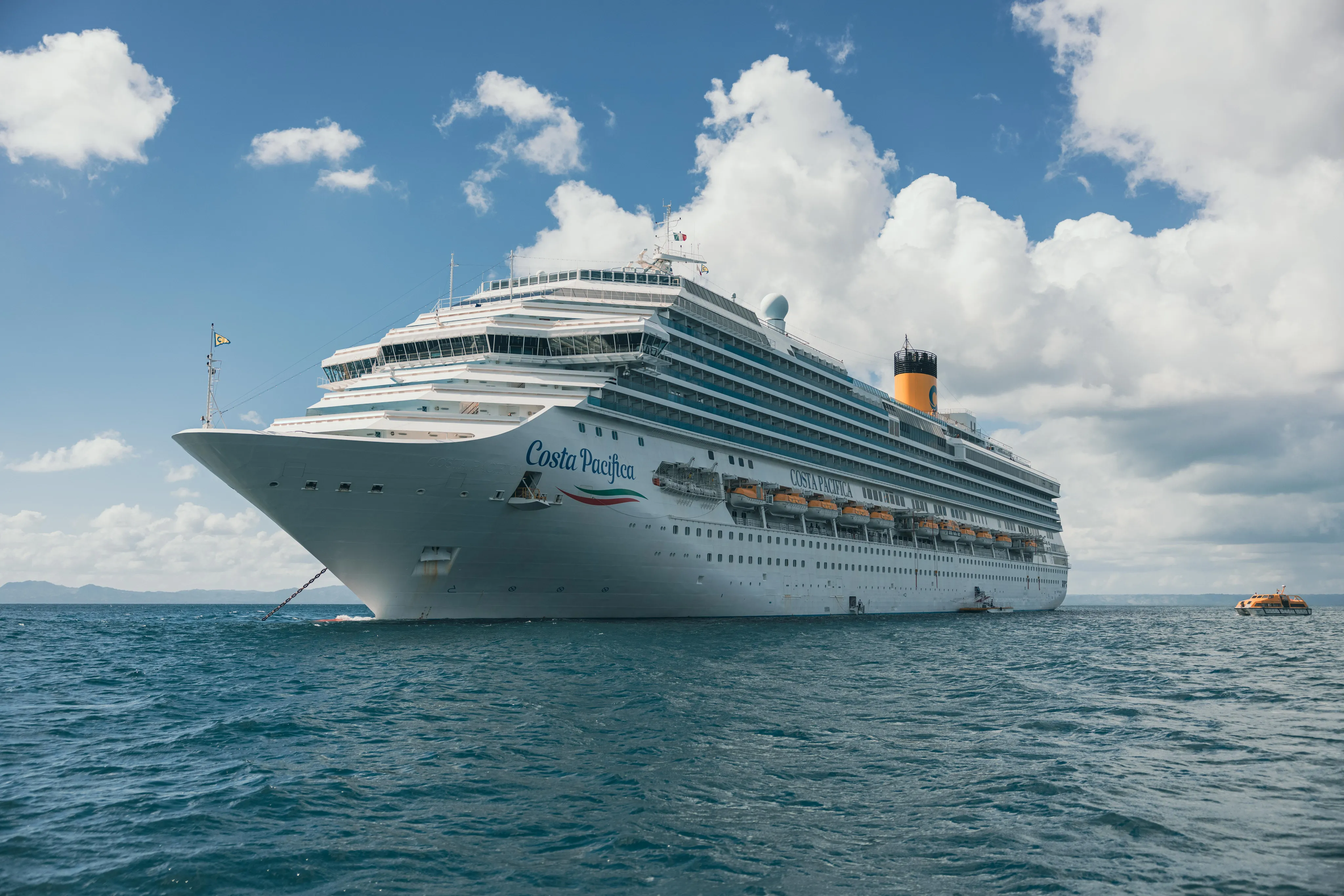 Costa Pacifica en Aguas Caribeñas Crucero Costa Pacifica anclado en aguas turquesas de Punta Cana, República Dominicana, con cielo azul y nubes blancas